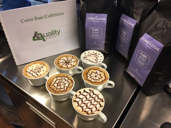 Sei cappuccini decorati con la latte art sul bancone del corso base di caffetteria