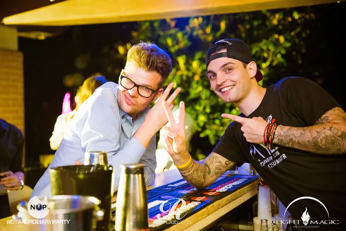 Due barman scherzano al bancone di una festa all'aperto